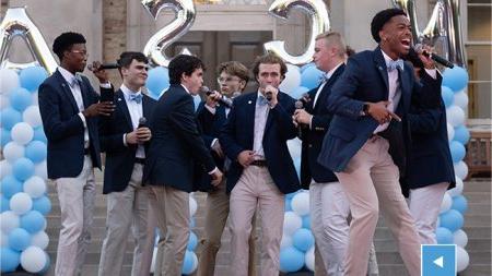 A student a cappella group performing at Sunset Serenade in front of South Building.